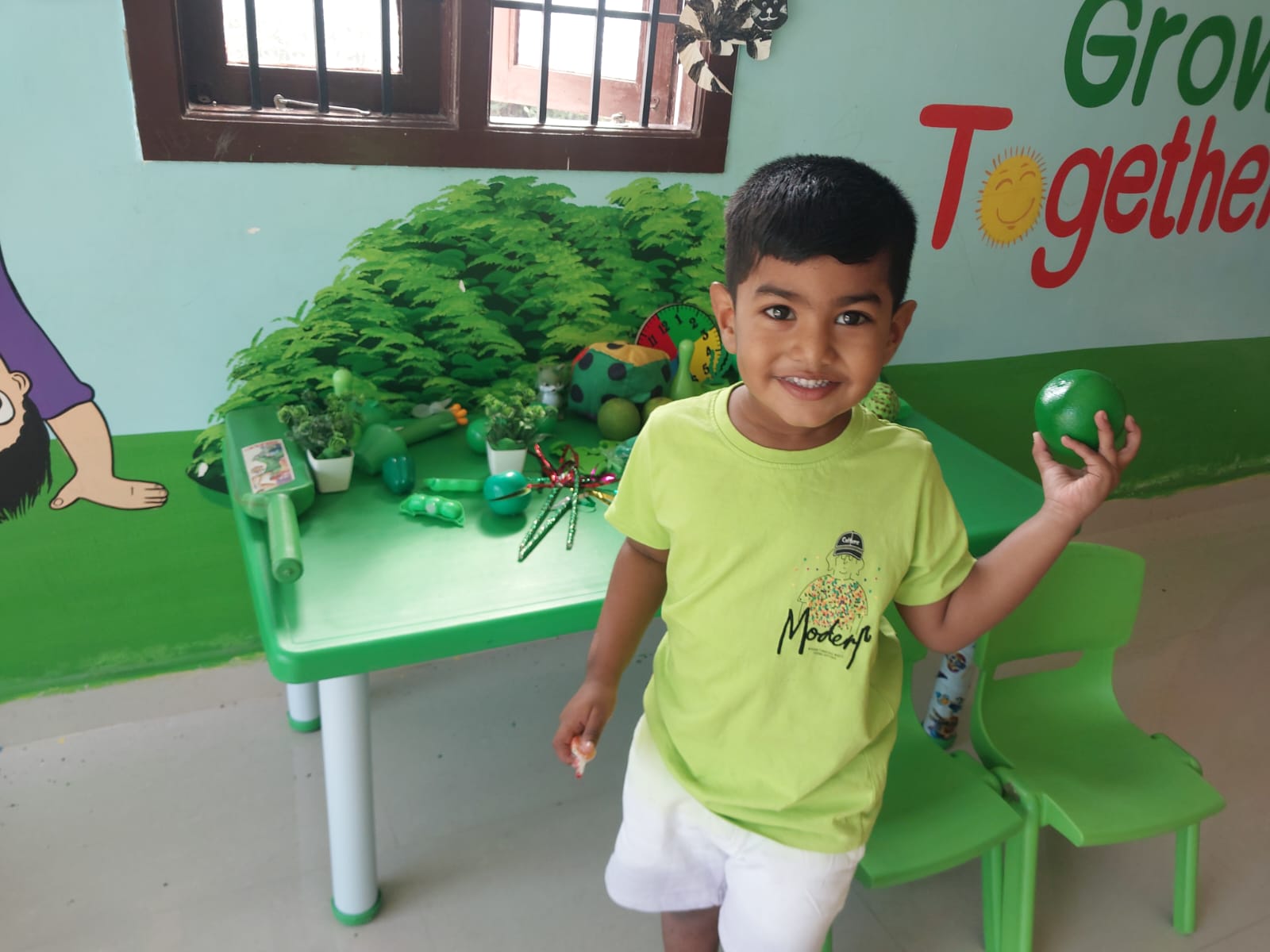 Child with a green-themed sensory nature display