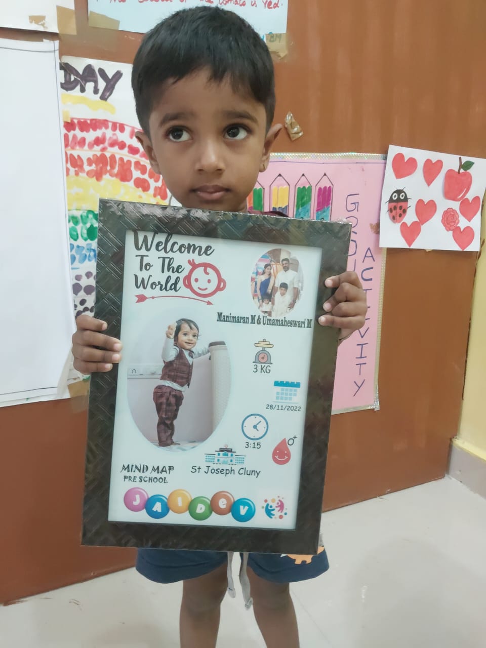 Child holding a handmade Welcome to the World craft photo frame