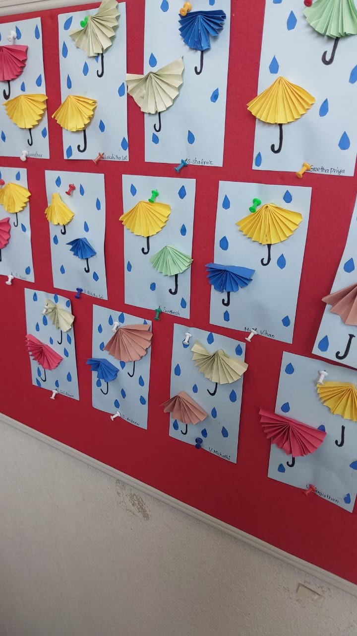 Colourful paper umbrella crafts displayed on a class board
